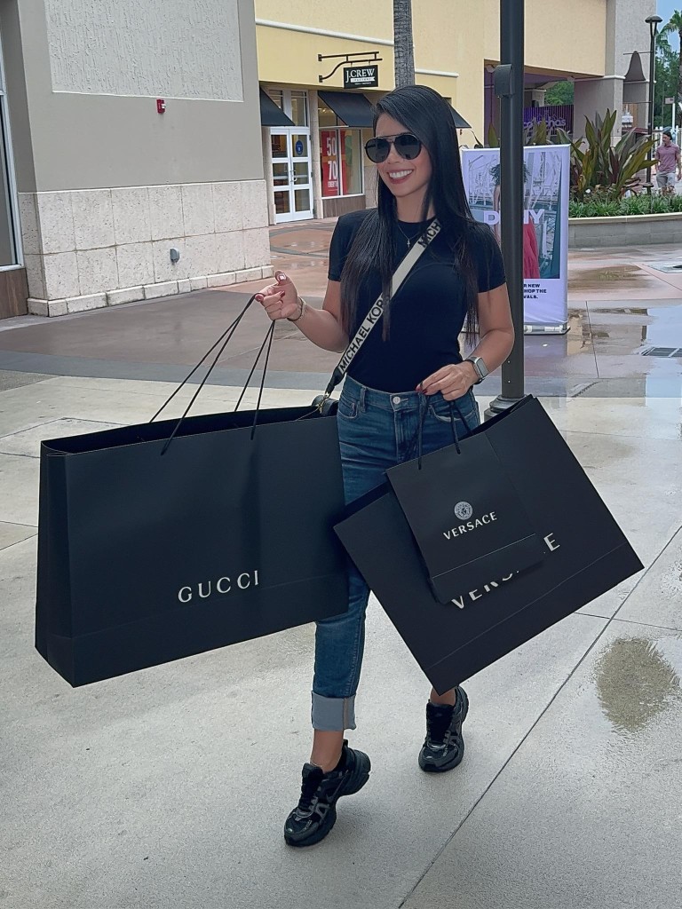 Lau con bolsas de Gucci y Versace