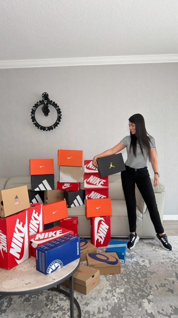 Lau junto a un pedido de cajas de tenis de varias marcas